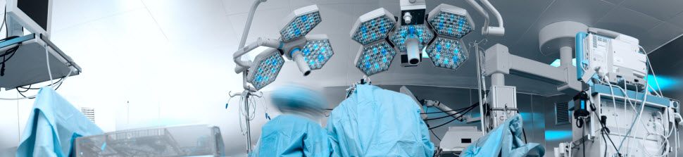 Panoramic image of the modern operating room with the personnel working with the patient