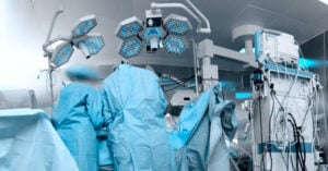 Panoramic image of the modern operating room with the personnel working with the patient