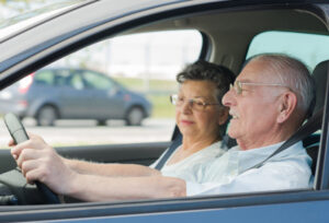 older man driving older woman passenger
