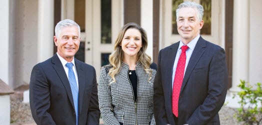 Shawn Cunningham, Caitlyn Haitaian, and Frank Powers in front of their law office building
