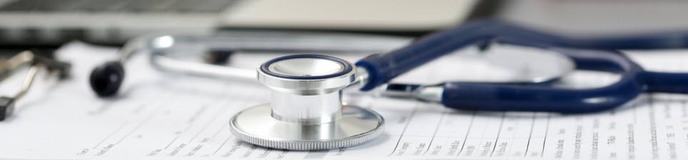 Stethoscope lying on medical form on clipboard pad